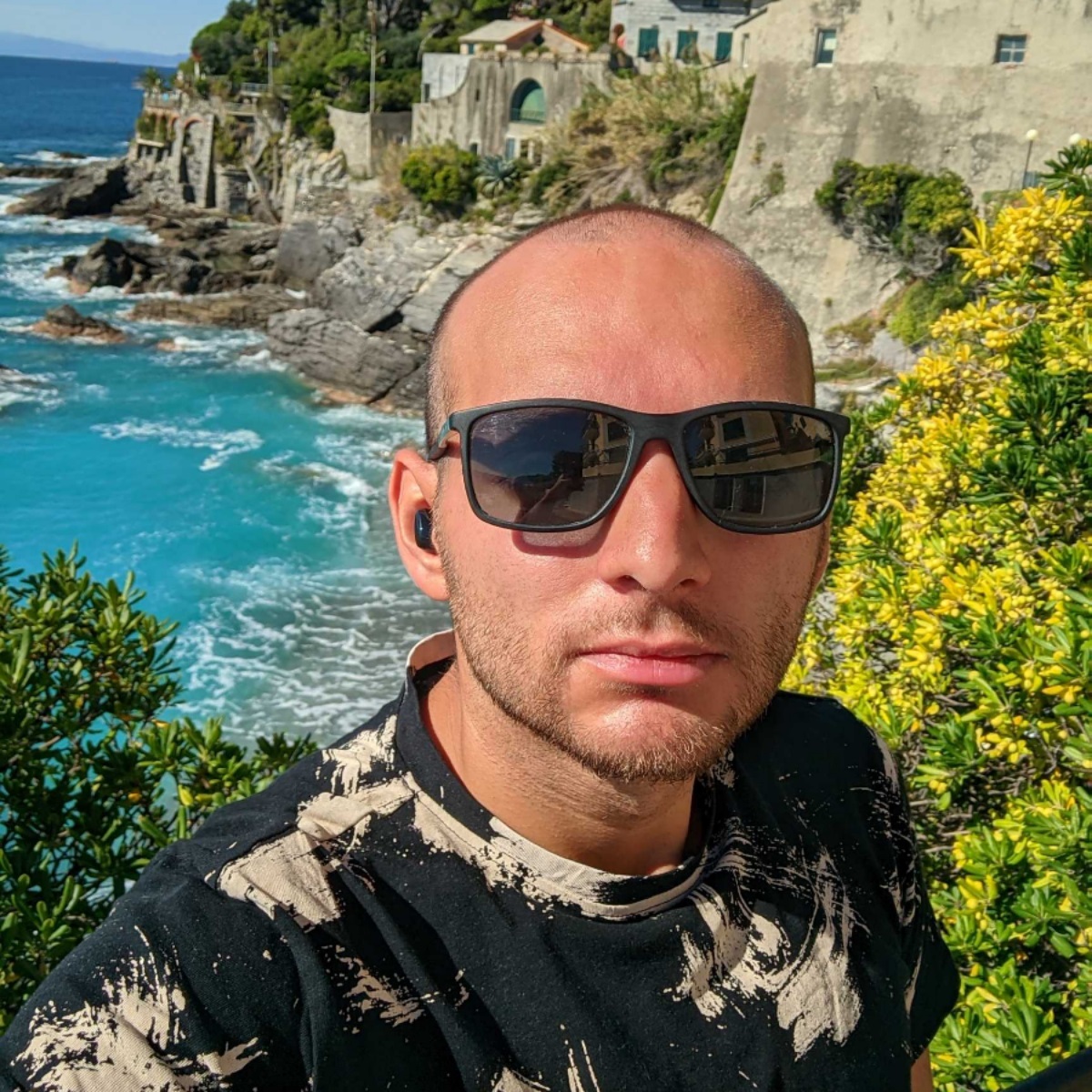 A selfie of myself in Summer, wearing sun glasses, standing in front of the sea